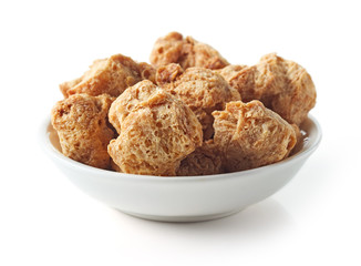 Bowl of soya chunks on white background