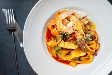 cooked pasta papardelle with beef and Basil in tomato sauce, top view