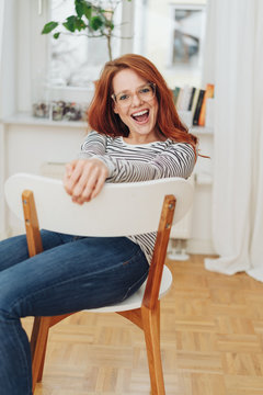 Laughing young woman seated on a chair