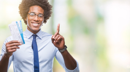 Afro american man holding boarding pass over isolated background surprised with an idea or question pointing finger with happy face, number one