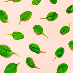 Fresh green spinach leaves pattern on pink background Flat lay top view. Creative food concept. Ingredient for salad. Vegetable pattern design. Healthy lifestyle.