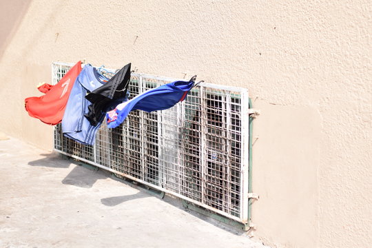 a colorful cloth hanging on the compressor build in an old wall.
