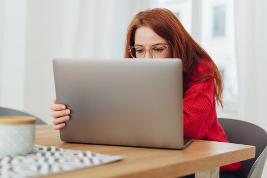 Young woman wearing glasses working on a laptop