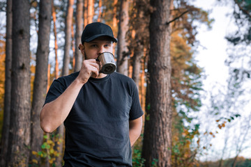 Portrait of handsome bearded man drinking hot tea outdoor in trip. Strong and brave man with beard have a rest on hiking trail. Time for relax.