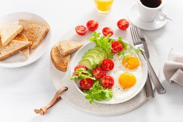 healthy breakfast with fried eggs, avocado, tomato, toasts and coffee