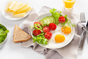 healthy breakfast with fried eggs, avocado, tomato, toasts and coffee