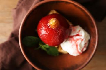 Sweet pear stewed in red wine and ice cream in bowl, top view