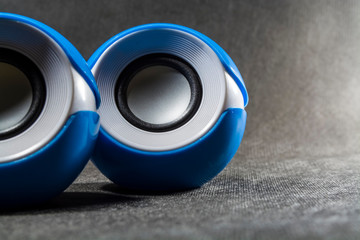 Small and portable round speakers for reproduction of music. Modern technologies. Electronics. Black background. Mobility.