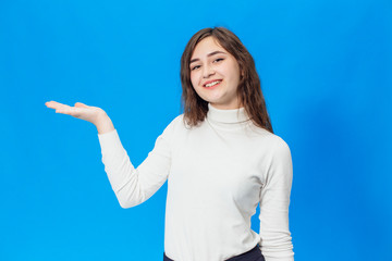 Fototapeta premium Young beautiful girl isolated on blue background