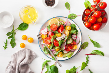 healthy colorful vegan tomato salad with cucumber, radish, onion