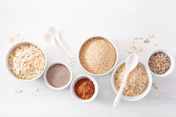 variaty of raw cereals and seeds for breakfast. Oatmeal flakes and steel cut, barley, chia. Healthy ingredients