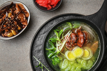 Tasty Chinese soup in bowl on grey table