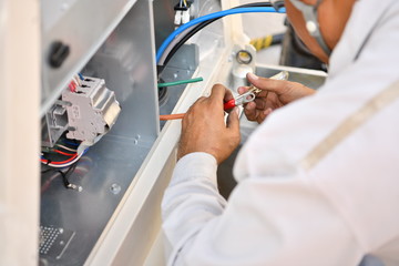 Technician connecting main cable power supply to chiller pump for the cooling water system in the...