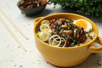 Tasty Chinese soup in pot on light table