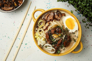 Tasty Chinese soup in pot on light table