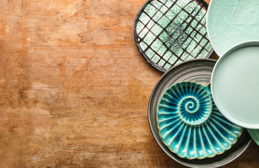 Set of stylish plates on wooden background