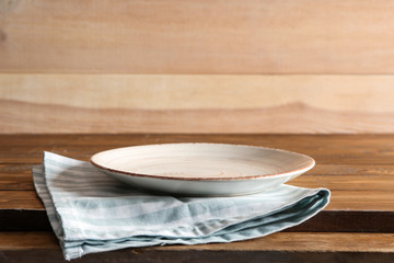 Stylish plate with napkin on wooden table