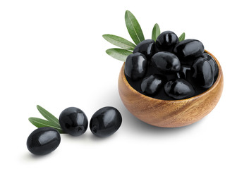 Delicious black olives with leaves in a wooden bowl, isolated on white background