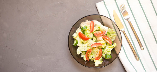 healthy salad, vegetable, tomatoes, cucumbers, iceberg, Cutlery, kitchen towel, grey background. Copy space. Vegetarian