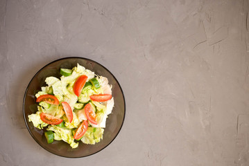 healthy salad, vegetable, tomatoes, cucumbers, iceberg, Cutlery, grey background. Top view. Copy space.