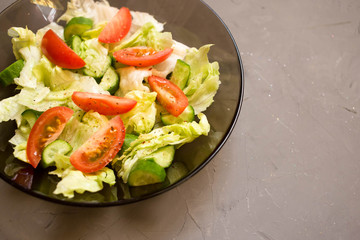 healthy salad, vegetable, tomatoes, cucumbers, iceberg, Cutlery, grey background. Top view. Copy space.
