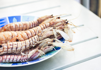 Boiled red shrimps prawns on the plate, seafood from the fish market of Catania, Sicily.