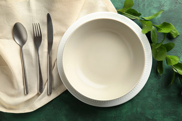 Beautiful table setting with floral decor on color background