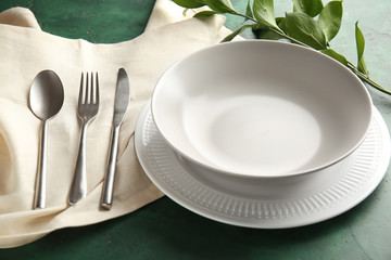 Beautiful table setting with floral decor on color background