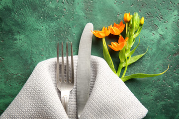 Beautiful table setting with flowers on color background