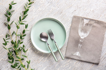 Beautiful table setting with floral decor on light wooden background