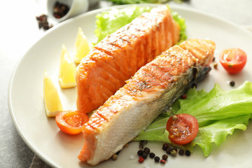 Pieces of tasty grilled salmon with spices on plate, closeup