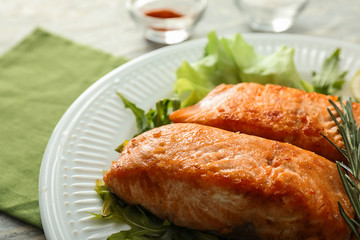 Pieces of tasty grilled salmon with vegetables on plate, closeup