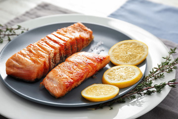 Pieces of tasty grilled salmon with lemon on plate