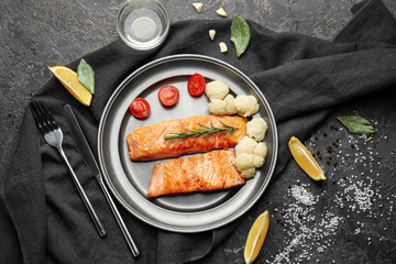 Pieces of tasty grilled salmon with vegetables on plate