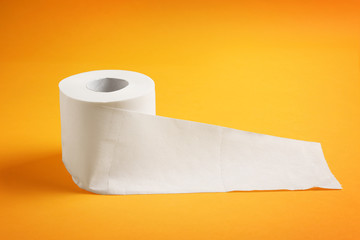 Roll of toilet paper on color background