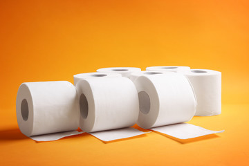 Rolls of toilet paper on color background