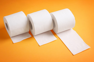 Rolls of toilet paper on color background