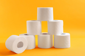 Rolls of toilet paper on color background