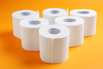 Rolls of toilet paper on color background