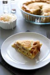 Slice of homemade sauerkraut pie on gray wooden table. Cabbage cake tradition russian food