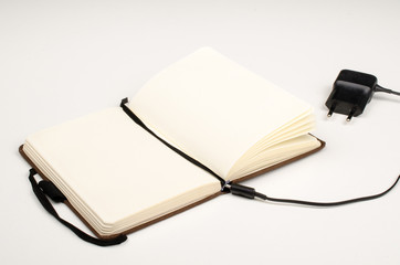 Small paper notebook and battery charger