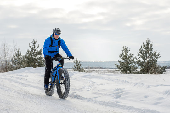 A young man riding fat bicycle in the winter