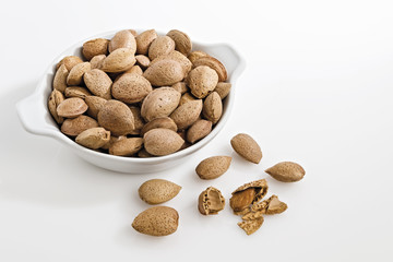 mandorle intere in ciotola fondo bianco