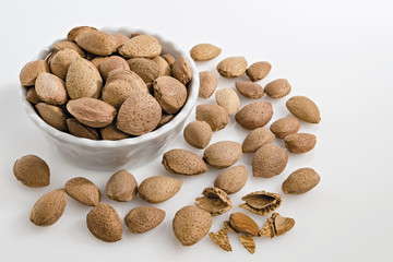 mandorle intere in ciotola fondo bianco