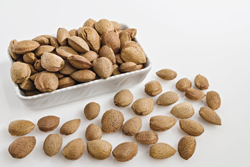 mandorle intere in ciotola fondo bianco