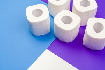 Rolls of toilet paper on color background, top view