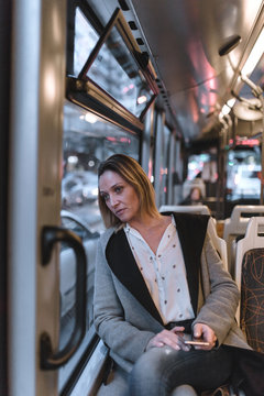 Front view of tired business woman looking through window in a bus