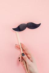 Woman hands with black paper moustaches