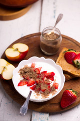 Natural yogurt with strawberries, peanut butter toast and apple. healthy breakfast