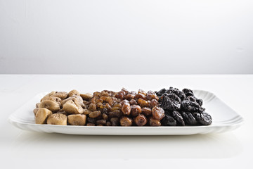 datteri prugne fichi uva passa vassoi fondo bianco